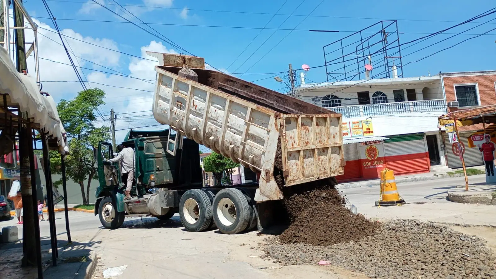 Camión de volteo Sterling descargando material de relleno en una calle