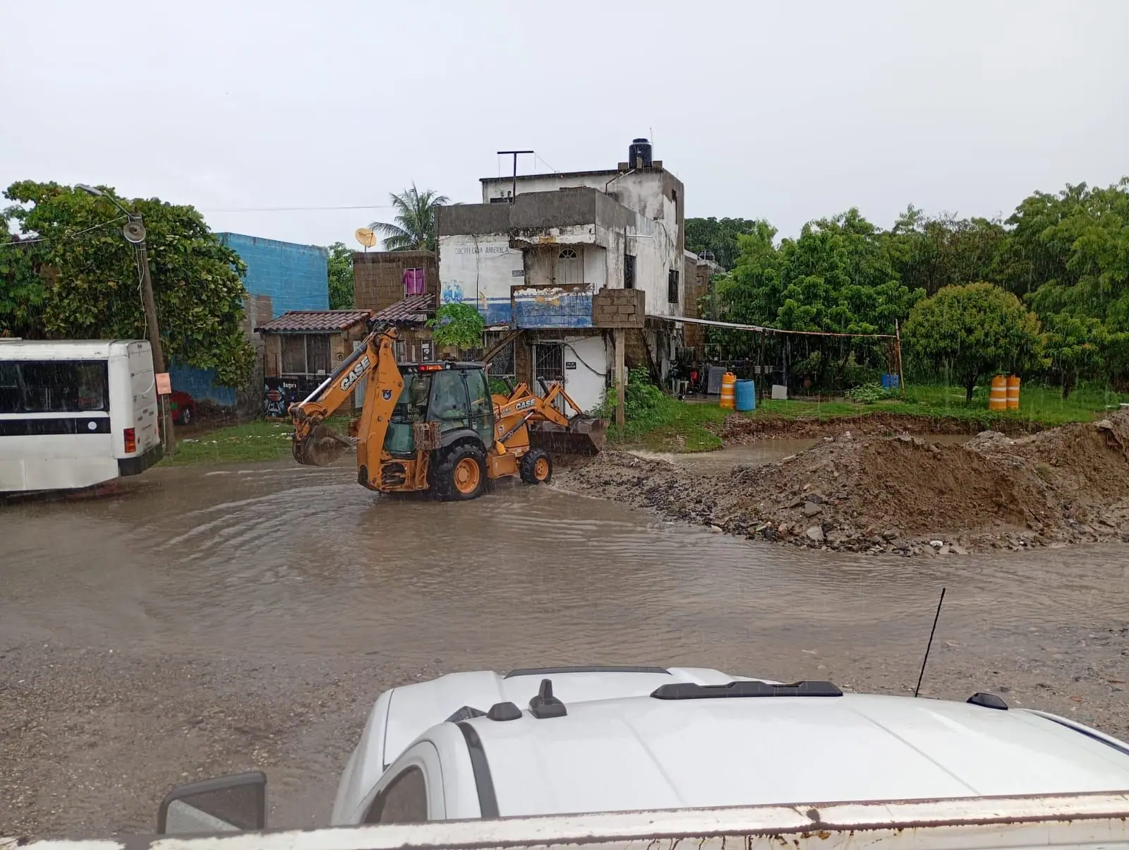 Retroexcavadora Case trabajando un relleno de material en una zona inundada